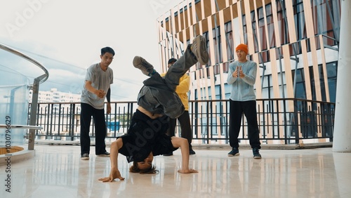 Hip hop team dance break dance while multicultural friend surrounded and clapping hands to cheer or encourage his friend to dance. Active and energetic street dance. Outdoor sport 2024. Hiphop. photo