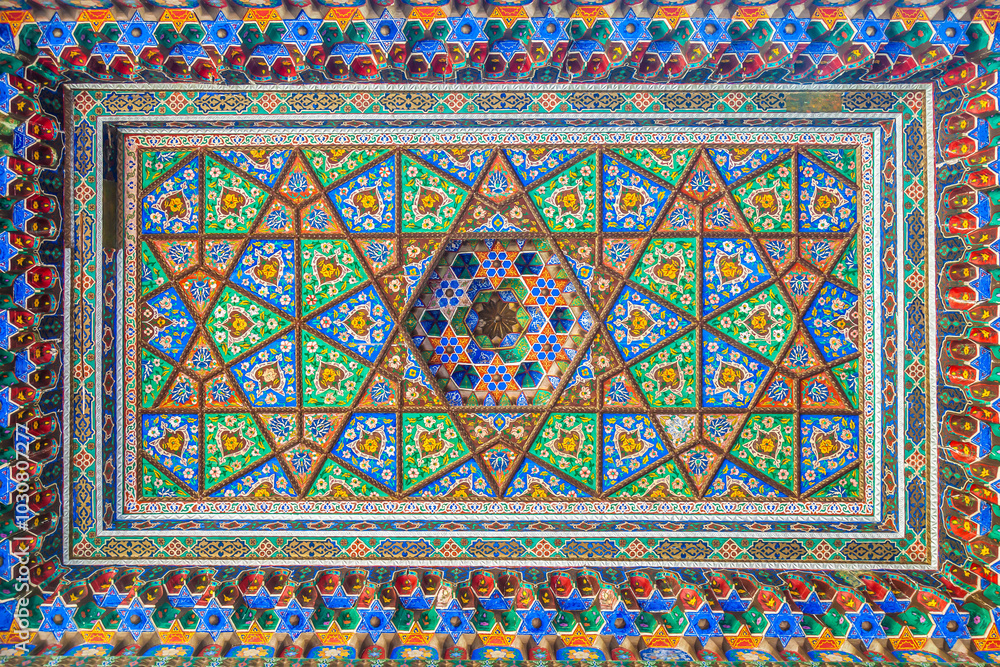 A beautiful wooden ceiling carved in oriental style and painted with Asian designs in a museum in Tashkent A beautiful wooden ceiling carved in oriental style and painted with Asian designs in a museum in Tashkent