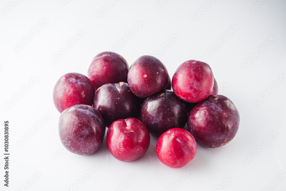 Isolated Summer Plums: Fresh and Juicy Red and Black Plums on a White Background Isolated Summer Plums: Fresh and Juicy Red and Black Plums on a White Background