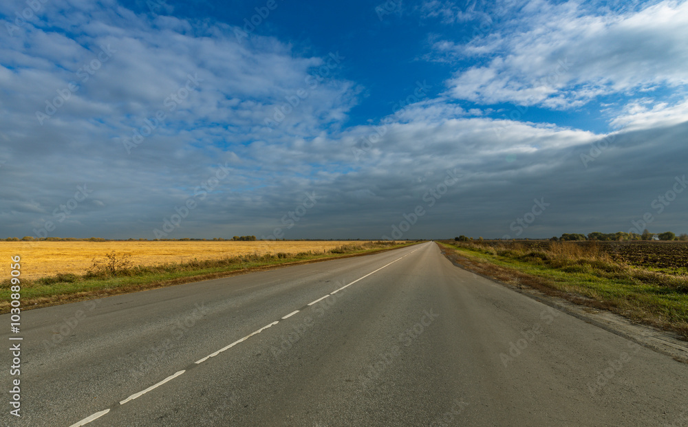 A long, empty road with a clear blue sky above A long, empty road with a clear blue sky above