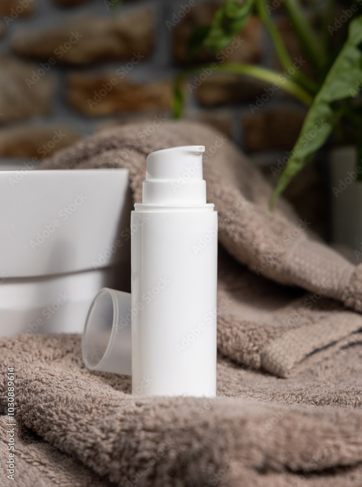 White cosmetic pump bottle on brown towels near basin and green plant close up, mockup White cosmetic pump bottle on brown towels near basin and green plant close up, mockup
