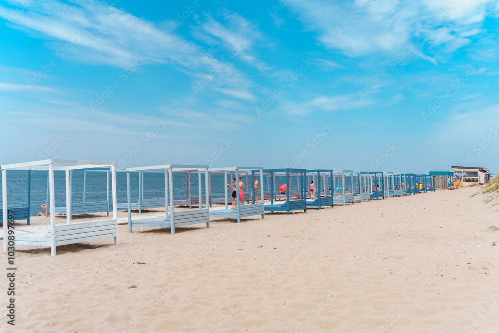 Beautiful beach in Yantarny with blue wooden sun beds and blue sky, Baltic Sea. Yantarny, Kaliningrad Oblast , Russia - 23 June 2024 Beautiful beach in Yantarny with blue wooden sun beds and blue sky, Baltic Sea. Yantarny, Kaliningrad Oblast , Russia - 23 June 2024