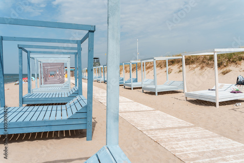 Beautiful beach in Yantarny with blue wooden sun beds and blue sky, Baltic Sea. Yantarny, Kaliningrad Oblast , Russia - 23 June 2024 photo