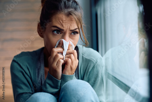 Woman with cold and flu virus blowing her nose. photo