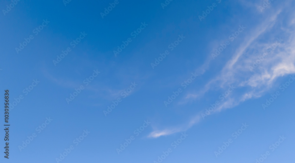 Clear blue sky with gentle clouds, perfect for backgrounds and design projects Clear blue sky with gentle clouds, perfect for backgrounds and design projects