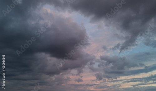 Dramatic clouds fill the sky, creating a stunning display of shadows and light at dusk. The interplay of colors is mesmerizing, perfect for backgrounds or nature themes.