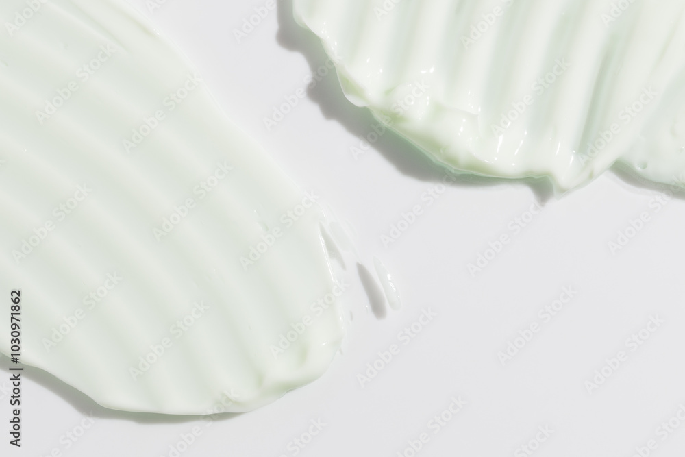 Green beauty cream smear smudge on white background. Cosmetic skincare product texture. Face cream, body lotion swipe swatch Green beauty cream smear smudge on white background. Cosmetic skincare product texture. Face cream, body lotion swipe swatch