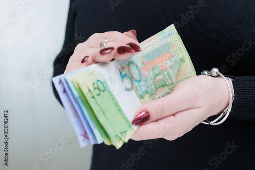 Female hands holding paper bills Belarusian rubles photo