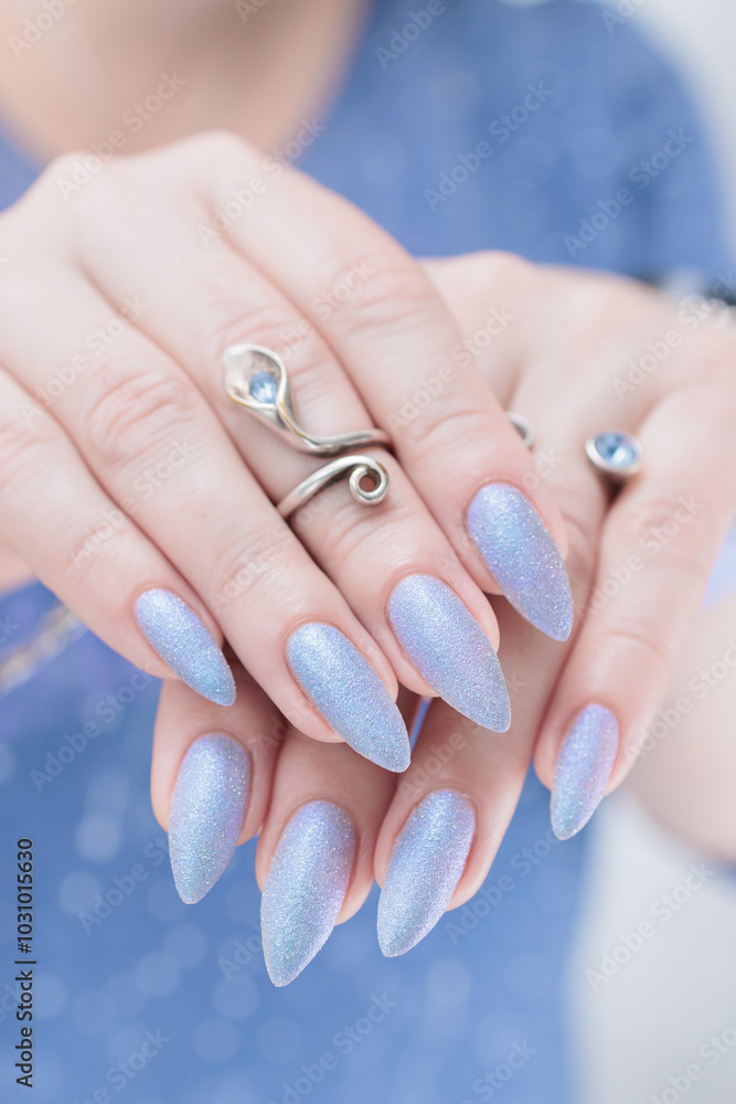 Woman hand with long nails manicure and light lilac and blue nail polish Woman hand with long nails manicure and light lilac and blue nail polish
