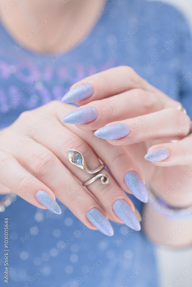 Woman hand with long nails manicure and light lilac and blue nail polish Woman hand with long nails manicure and light lilac and blue nail polish