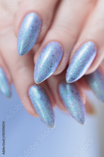 Woman hand with long nails manicure and light lilac and blue nail polish