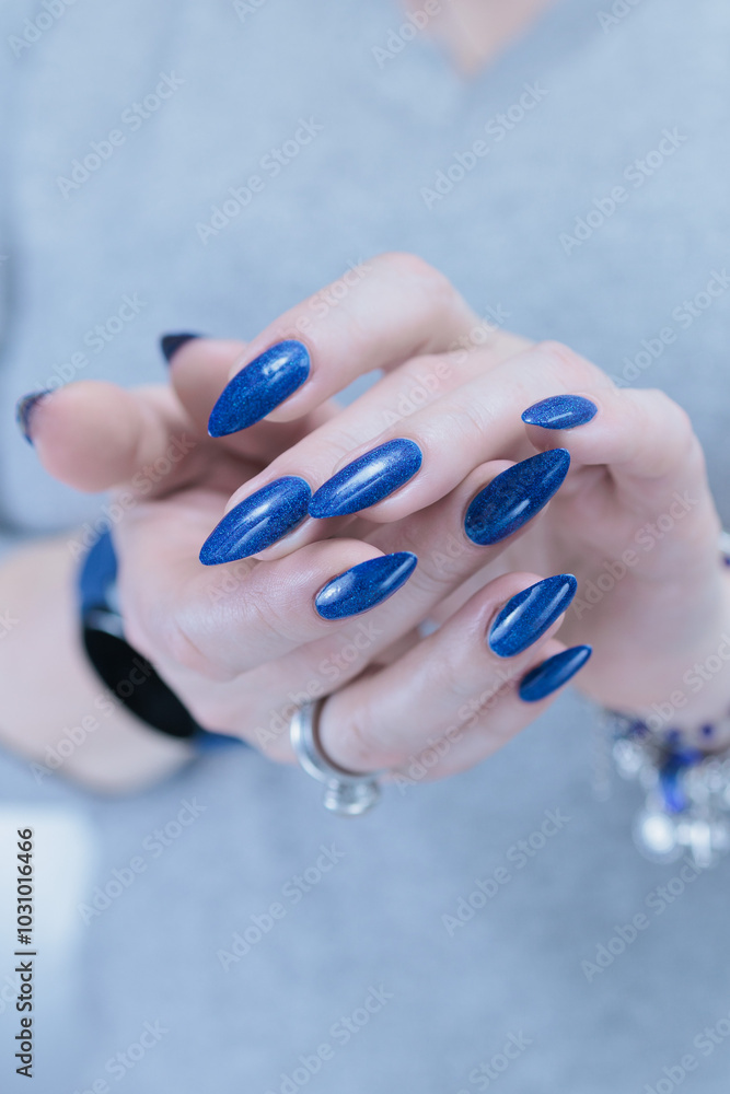 Female hand with long nails and a blue and purple color nail polish Female hand with long nails and a blue and purple color nail polish