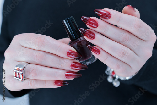 Female hands with long nails and black and red nail polish photo