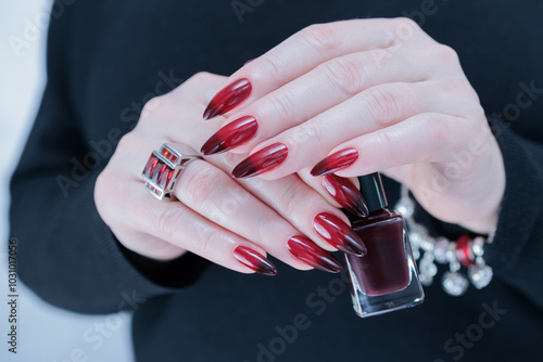 Female hands with long nails and black and red nail polish photo