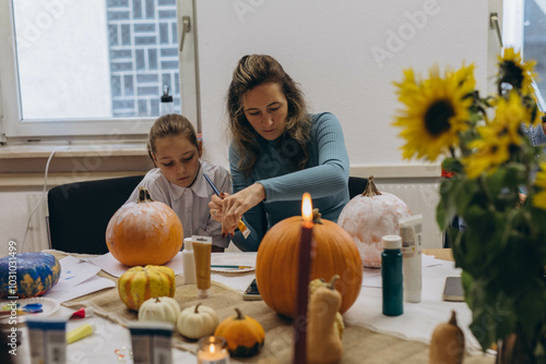 Children and adults painting pumpkins for Halloween, enjoying a fun and creative activity together. photo