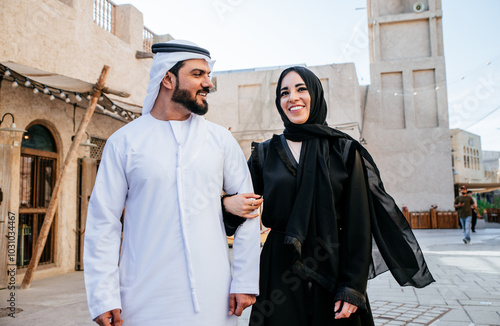 Happy couple spending time in Dubai. man and woman wearing traditional clothes making shopping in the old city