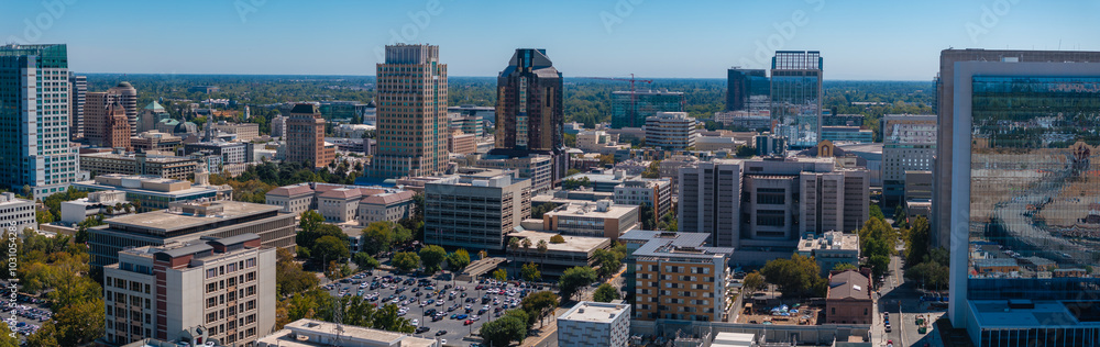 Obraz premium Aerial view of Sacramento, California, featuring modern skyscrapers like Wells Fargo Center and US Bank Tower, with lush greenery in the background.
