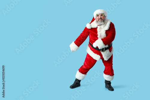 Funny Santa Claus dancing on blue background