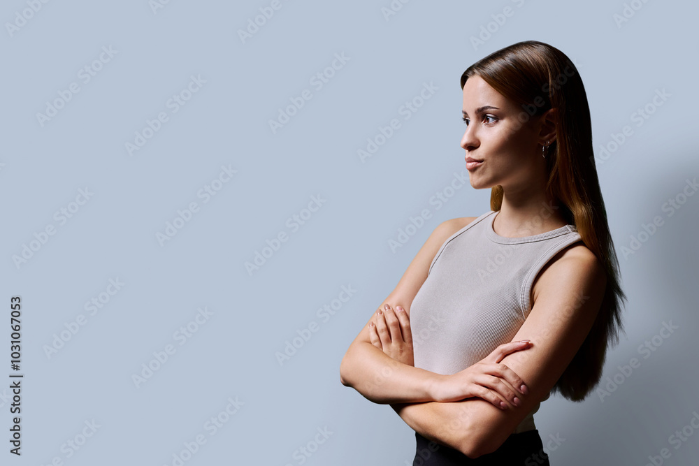 Obraz premium Profile view, confident young teenage woman, copy space gray background