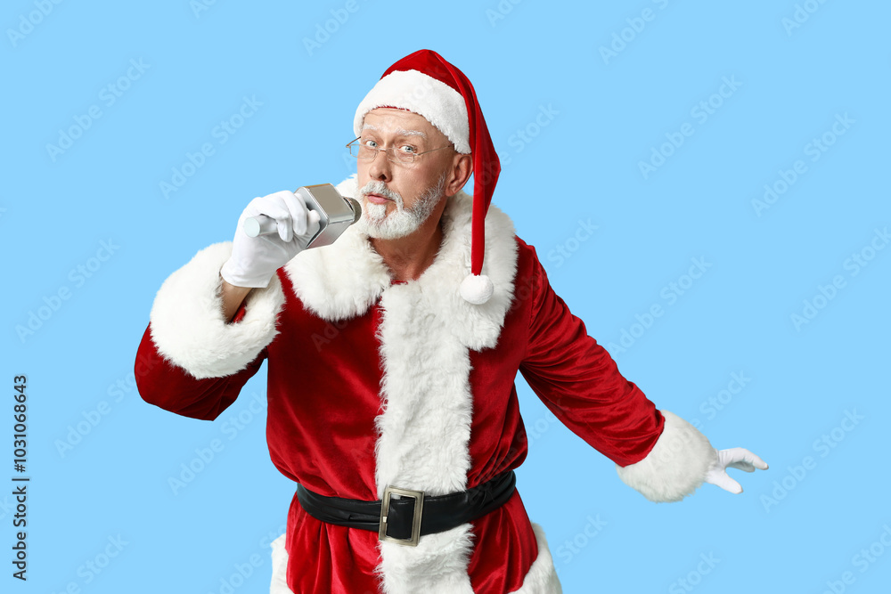Santa Claus in glasses with microphone singing on blue background Santa Claus in glasses with microphone singing on blue background