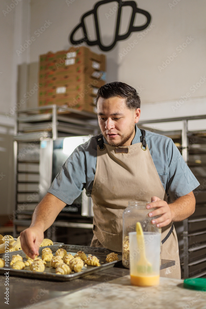 In a modern kitchen setting, the baker expertly sprinkles almonds onto pastries arranged on a tray, showcasing both creativity and precision in the art of baking. In a modern kitchen setting, the baker expertly sprinkles almonds onto pastries arranged on a tray, showcasing both creativity and precision in the art of baking.