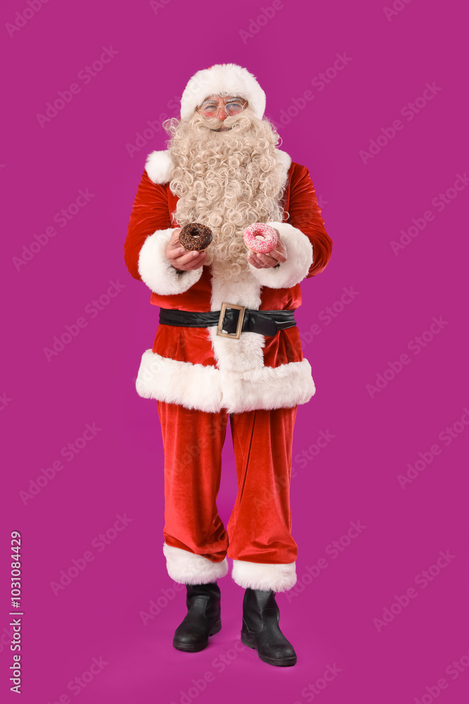 Santa Claus with tasty donuts on purple background Santa Claus with tasty donuts on purple background