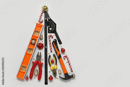 Christmas tree made of construction tools and decorations on light background photo