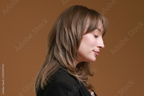 Attractive woman with stylish haircut on brown background