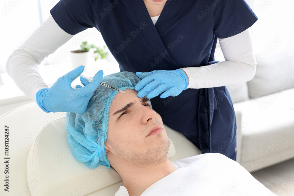 Young man receiving injection from plastic surgeon on couch in clinic, closeup Young man receiving injection from plastic surgeon on couch in clinic, closeup