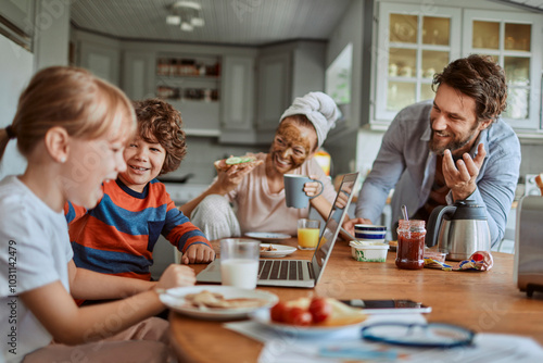 Family laughing during breakfast in kitchen