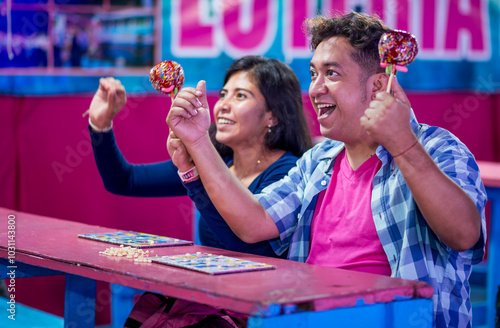Fotografie Close-up side shot of a couple of friends visiting the fair and playing the lottery, celebrating having won a prize