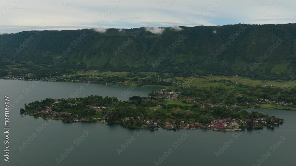 Aerial drone of Tourist spot Tuk Tuk on Lake Toba and the coast of Samosir Island. Sumatra, Indonesia. Tropical landscape. Aerial drone of Tourist spot Tuk Tuk on Lake Toba and the coast of Samosir Island. Sumatra, Indonesia. Tropical landscape.