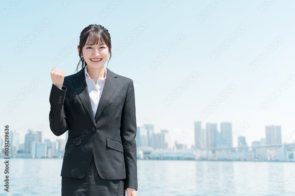 就職・転職・リクルート・青空の中に立つスーツ姿のビジネスウーマン
