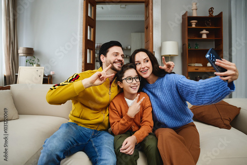 Family enjoying a cozy indoor moment while taking a selfie together