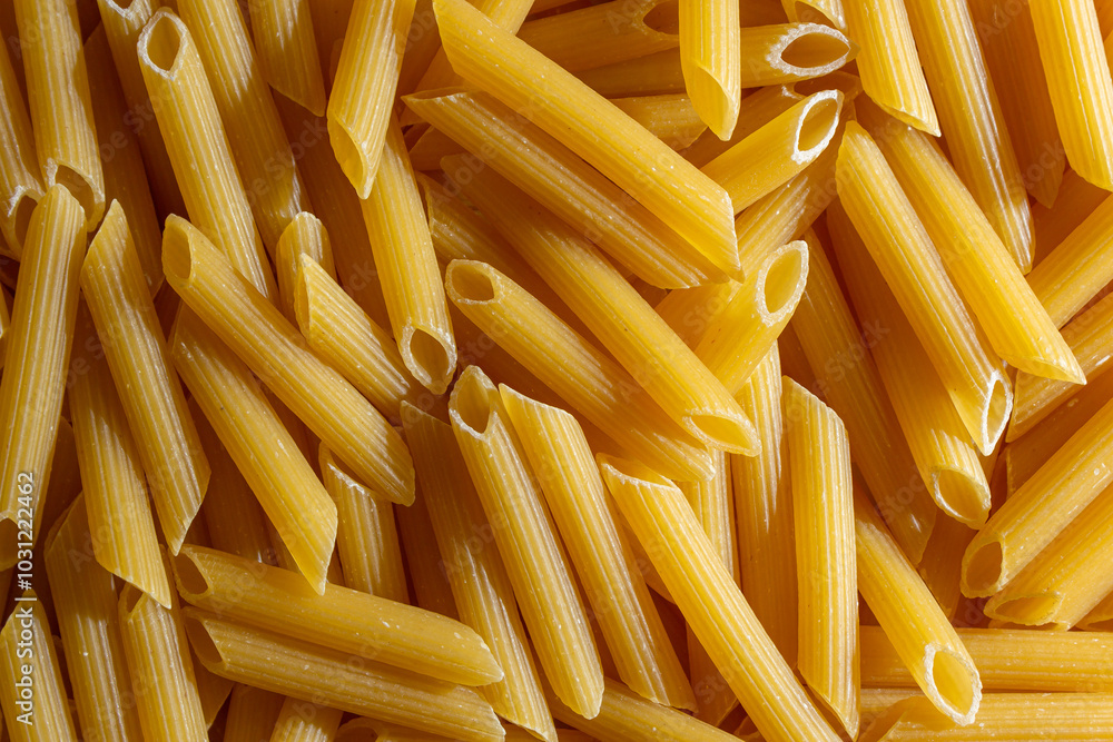 Uncooked Penne Rigate Pasta: A Culinary Canvas of Penne Macaroni, Creating a Lively and Textured Background for Gourmet Cooking. Dry Pasta. Raw Macaroni - Top View, Flat Lay Uncooked Penne Rigate Pasta: A Culinary Canvas of Penne Macaroni, Creating a Lively and Textured Background for Gourmet Cooking. Dry Pasta. Raw Macaroni - Top View, Flat Lay