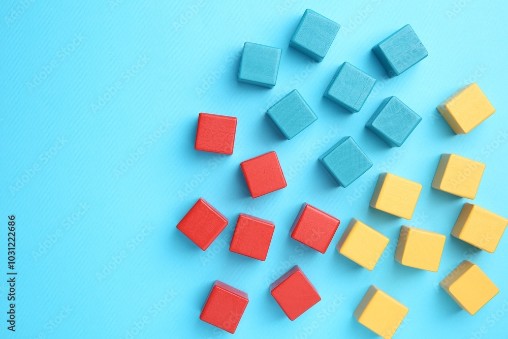 Many colorful cubes on light blue background, flat lay Many colorful cubes on light blue background, flat lay
