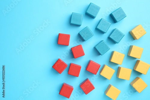 Many colorful cubes on light blue background, flat lay