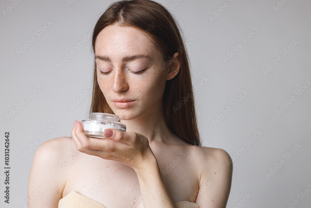 Studio portrait of a woman holding jar with face cream Studio portrait of a woman holding jar with face cream
