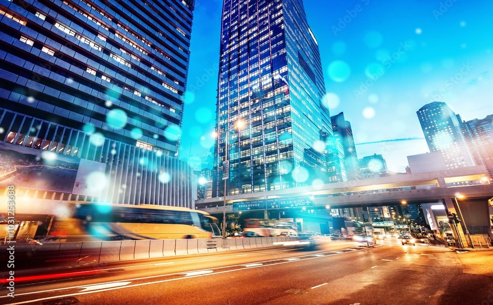 A nighttime view of a busy Hong Kong street with tall skyscrapers, speeding traffic, and a bright blue sky. A nighttime view of a busy Hong Kong street with tall skyscrapers, speeding traffic, and a bright blue sky.