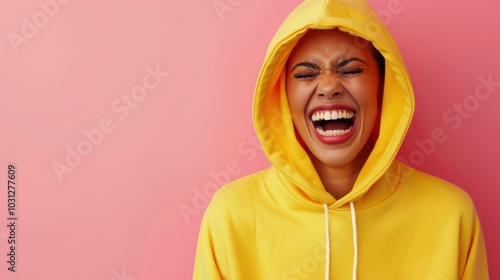 A vibrant portrait of a joyful young woman in a yellow hoodie, radiating happiness against a bright pink backdrop. photo