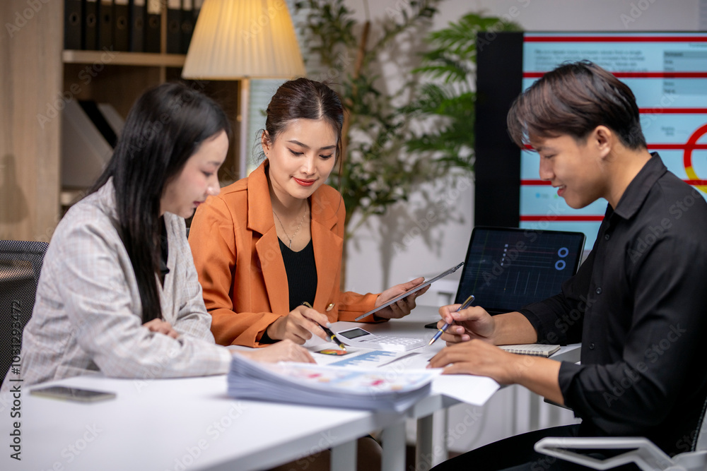 Asian business team working with data charts on desk in office