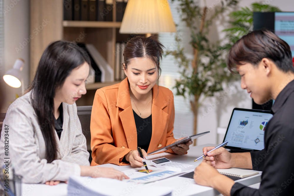 Group of asian business people analyzing business data on office desk Group of asian business people analyzing business data on office desk