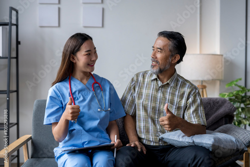 Doctor giving thumbs up sign with patient during home healthcare visit