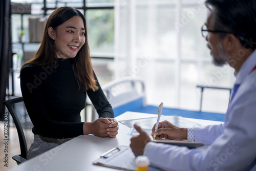 Wallpaper Mural Young woman smiling while talking to doctor taking notes Torontodigital.ca
