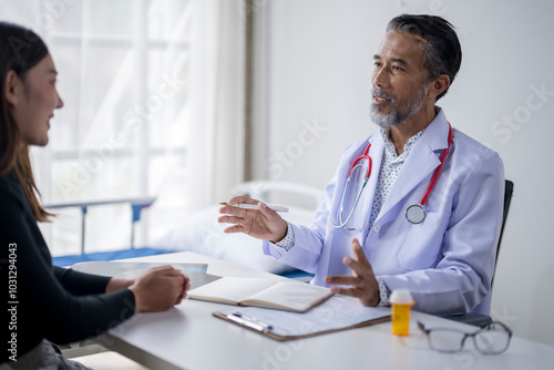 Senior doctor explaining diagnosis to patient during medical consultation in hospital room