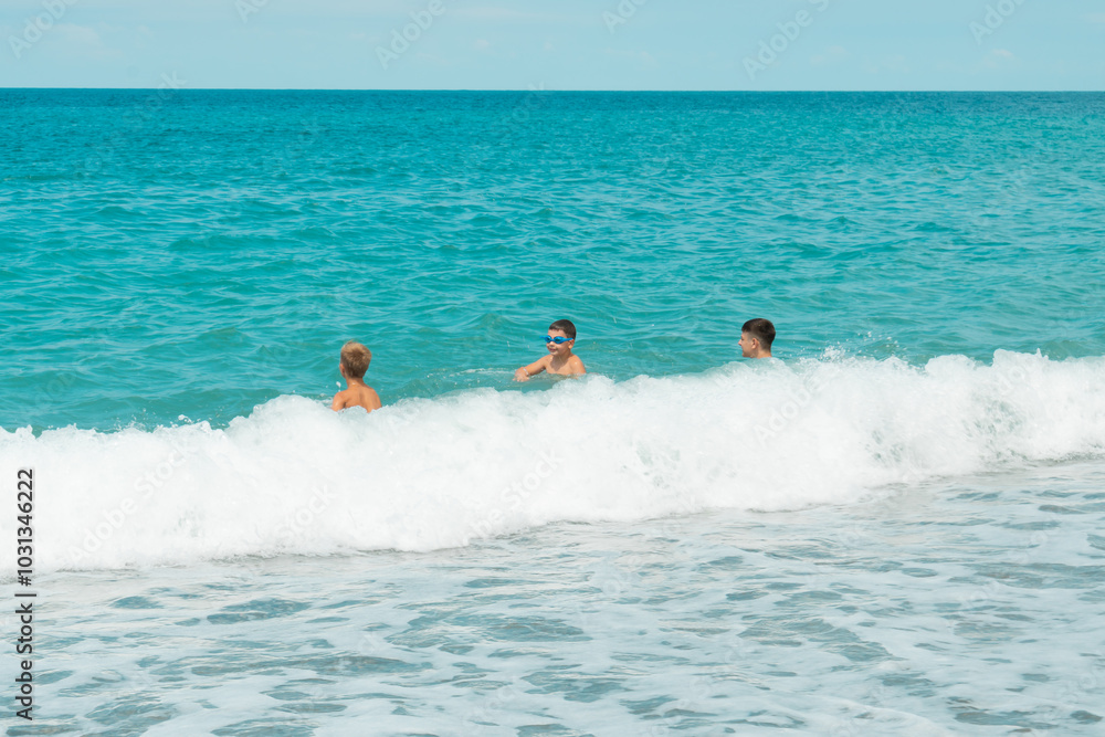 A group of children swim in the turquoise sea on summer holidays A group of children swim in the turquoise sea on summer holidays