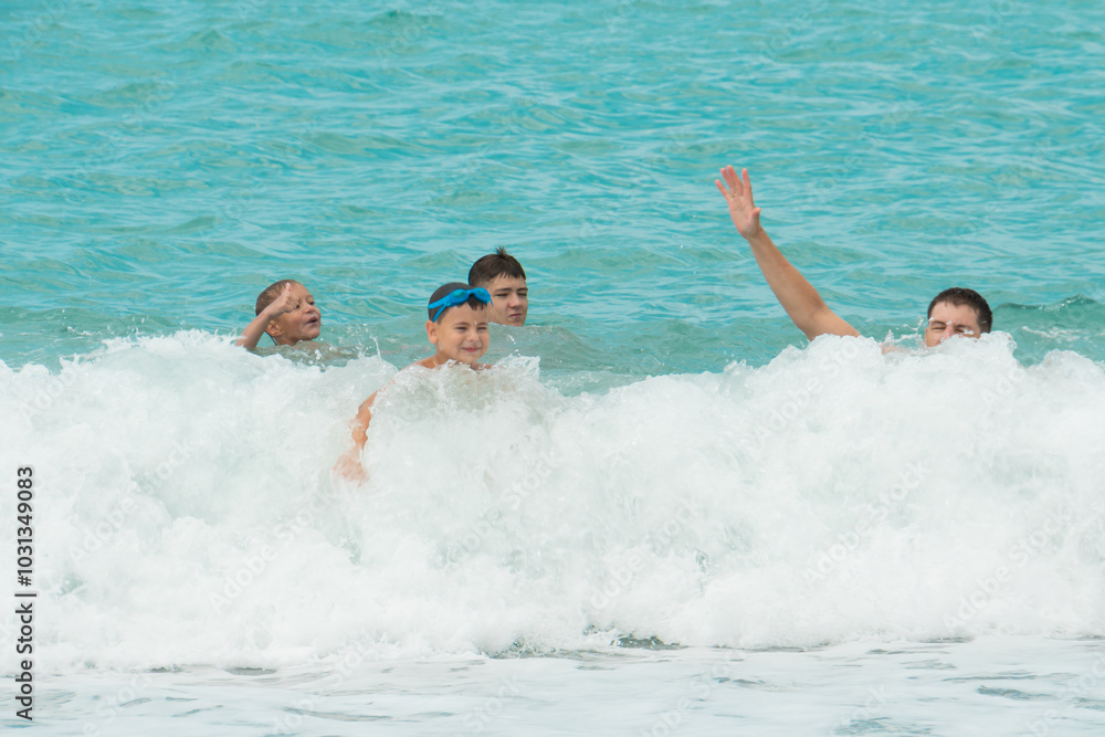 Father and sons swim in the turquoise sea Father and sons swim in the turquoise sea