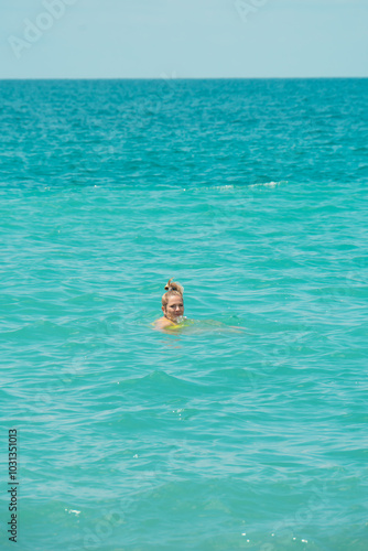 People swim in the beautiful turquoise sea in the hot summer