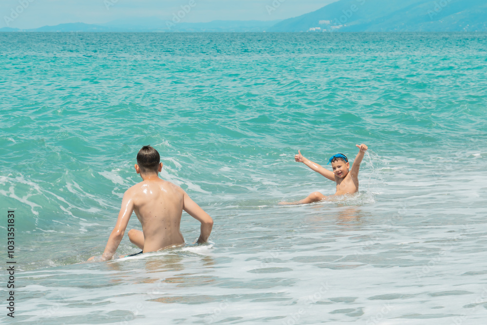 A group of children swim in the turquoise sea on summer holidays A group of children swim in the turquoise sea on summer holidays