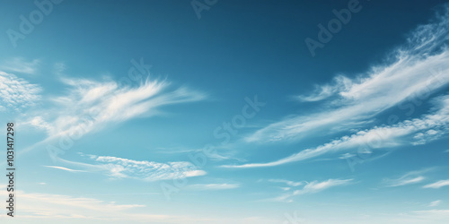 Clear blue sky with soft, wispy clouds drifting across, evoking a sense of peace, freedom, and open possibilities